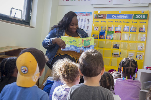 A photo of a teacher reading to young students.